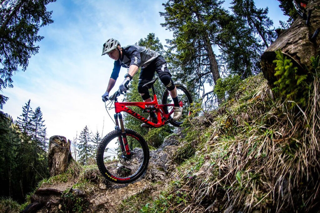 extreme mountain biker descending down rocky terrain on full suspension mountain bike